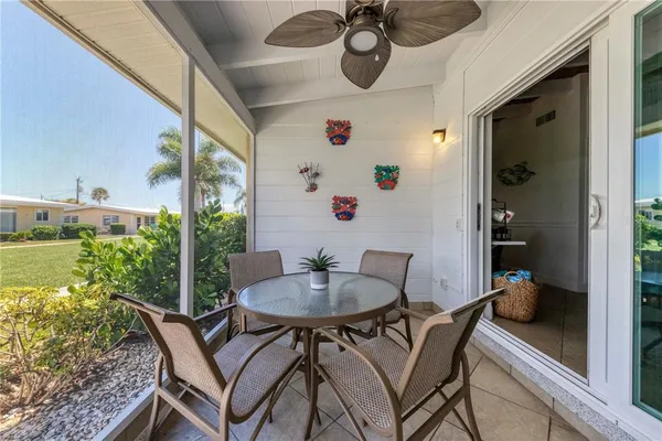 a balcony with a table and chairs and a potted plant