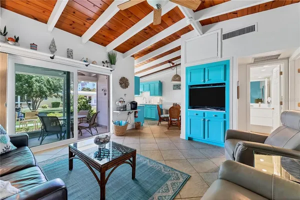 a living room with furniture a flat screen tv and a floor to ceiling window