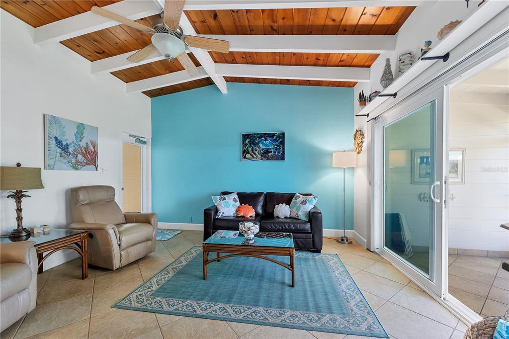 6006 Midnight Pass Road, Unit 16 Sarasota, FL 34242 - Photo 5 of 52 a living room with furniture a rug and a painting on the wall