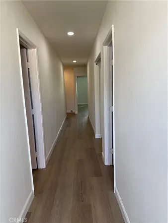 a view of a hallway with wooden floor