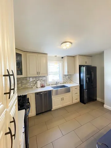 a large kitchen with a stove a refrigerator and a sink