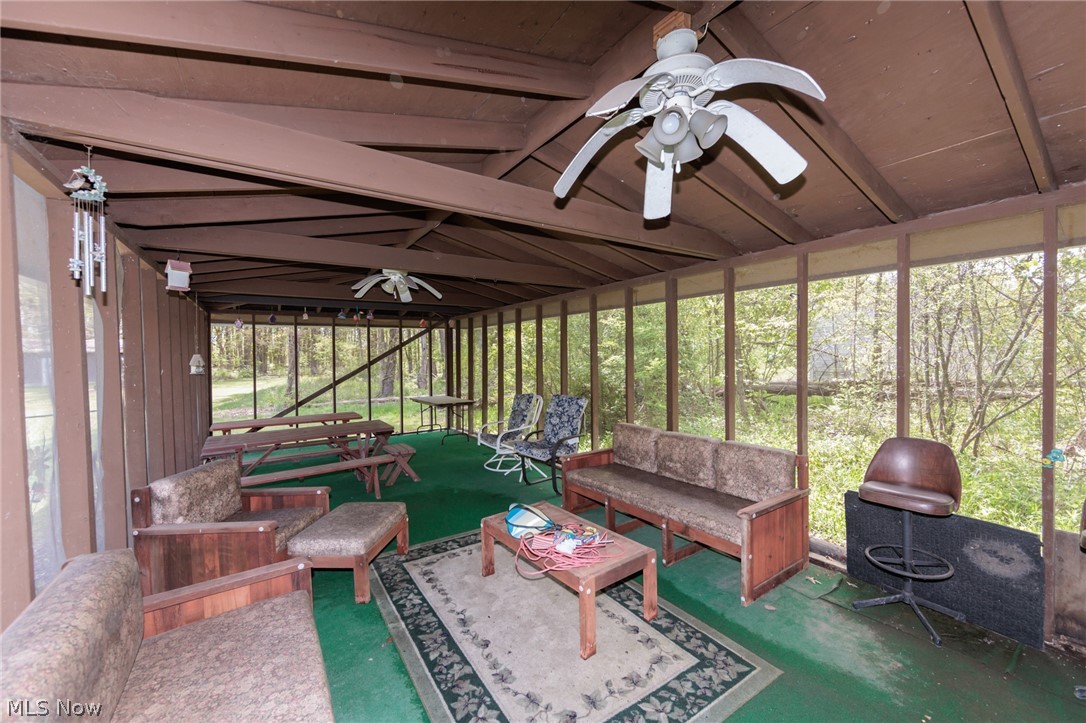 2170 Norton Road Stow, OH 44224 - Photo 13 of 48 Screened outdoor living area featuring a wood-beam ceiling, green carpet flooring, and multiple ceiling fans