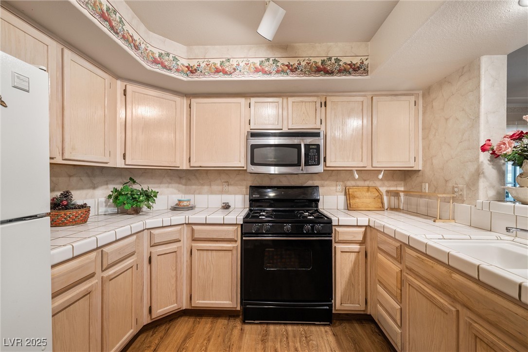 7950 West Flamingo Road, Unit 1024 Las Vegas, NV 89147 - Photo 12 of 30 Kitchen with stainless steel microwave, black rang