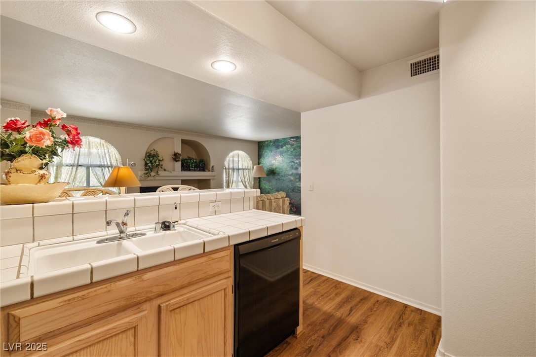 7950 West Flamingo Road, Unit 1024 Las Vegas, NV 89147 - Photo 15 of 30 Kitchen with black dishwasher, wood finished floor