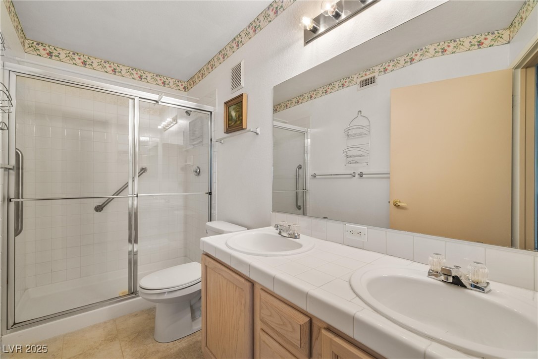 7950 West Flamingo Road, Unit 1024 Las Vegas, NV 89147 - Photo 21 of 30 Bathroom with a stall shower, double vanity, and t