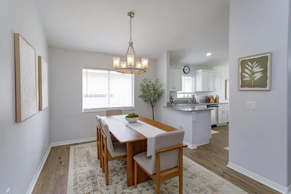 a kitchen with a dining table chairs and cabinets