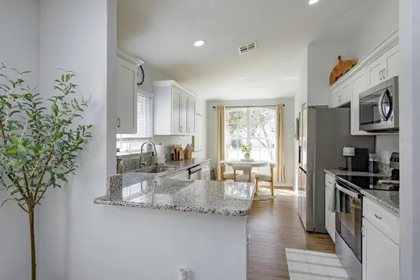 a kitchen that has a lot of cabinets in it and wooden floors