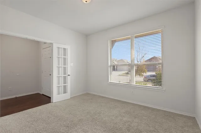 a kitchen with stainless steel appliances granite countertop a stove top oven a sink a refrigerator and white cabinets with wooden floor