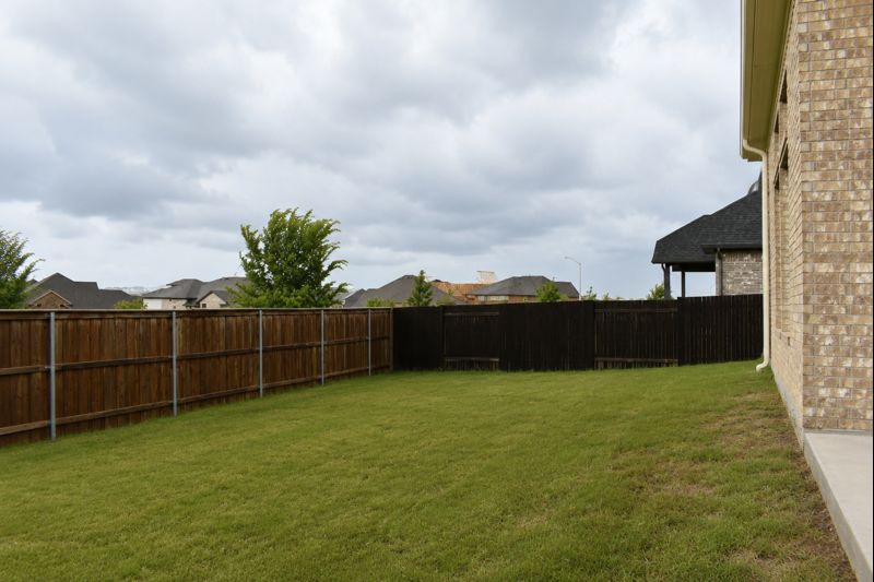 693 Durian Loop Buda, TX 78610 - Photo 20 of 27 A spacious, well-maintained lawn with privacy fencing surrounds this appealing residence.