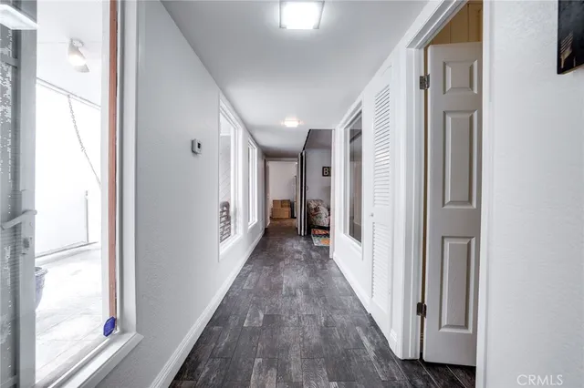 a view of a hallway with wooden floor and windows