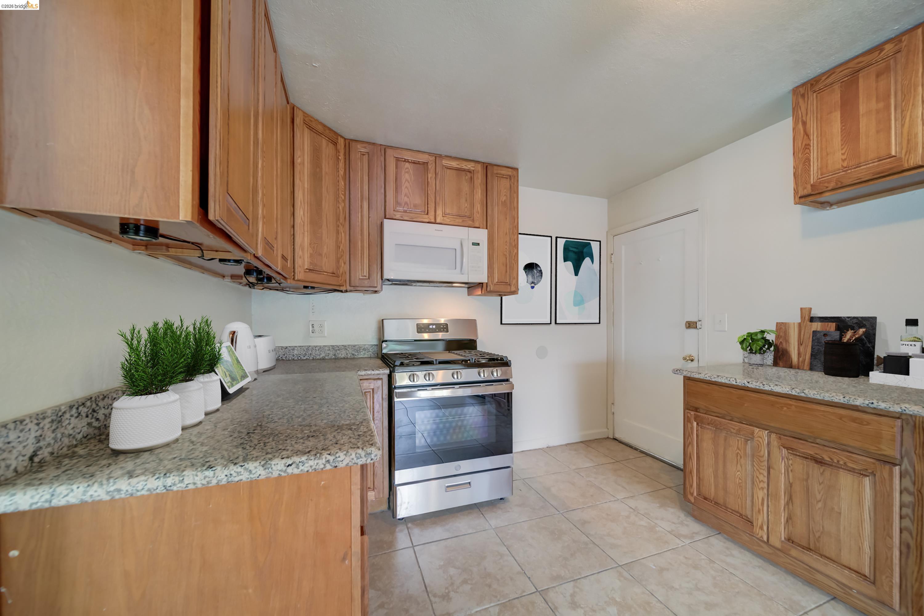 844 37th Street Richmond, CA 94805 - Photo 13 of 35 a kitchen with granite countertop a sink stove and cabinets