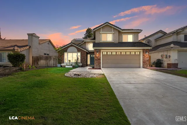 a front view of a house with a garden and yard