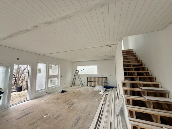 a view of a bedroom with wooden floor and stairs
