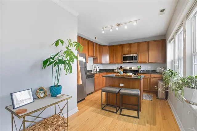 a kitchen with granite countertop white cabinets and stainless steel appliances
