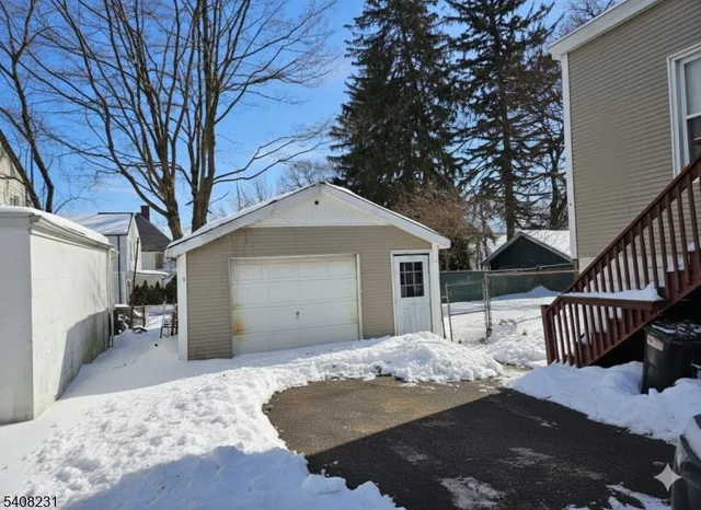 a backyard of a house with wooden fence and large trees