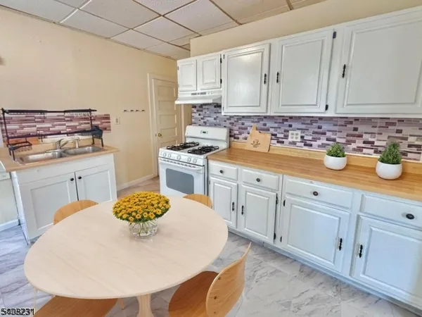 a kitchen with cabinets a sink and white appliances