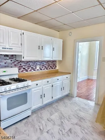a kitchen with granite countertop white cabinets and white appliances