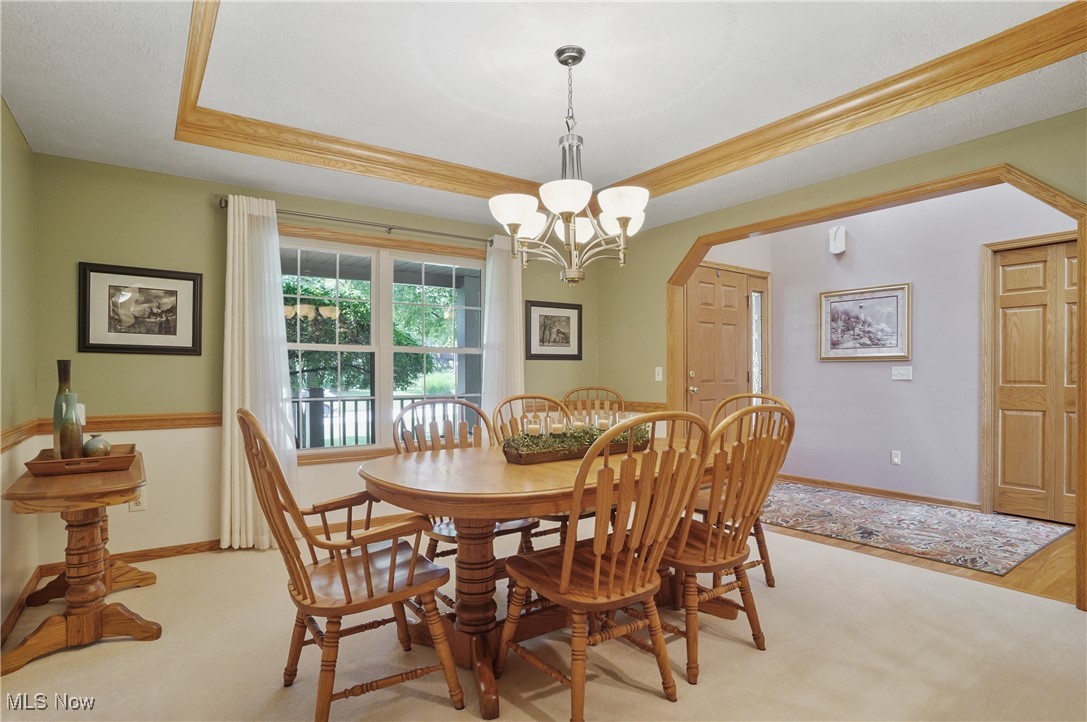 4265 Ridge Crest Drive Akron, OH 44321 - Photo 9 of 49 Dining room featuring a raised ceiling, a chandelier, and light carpet