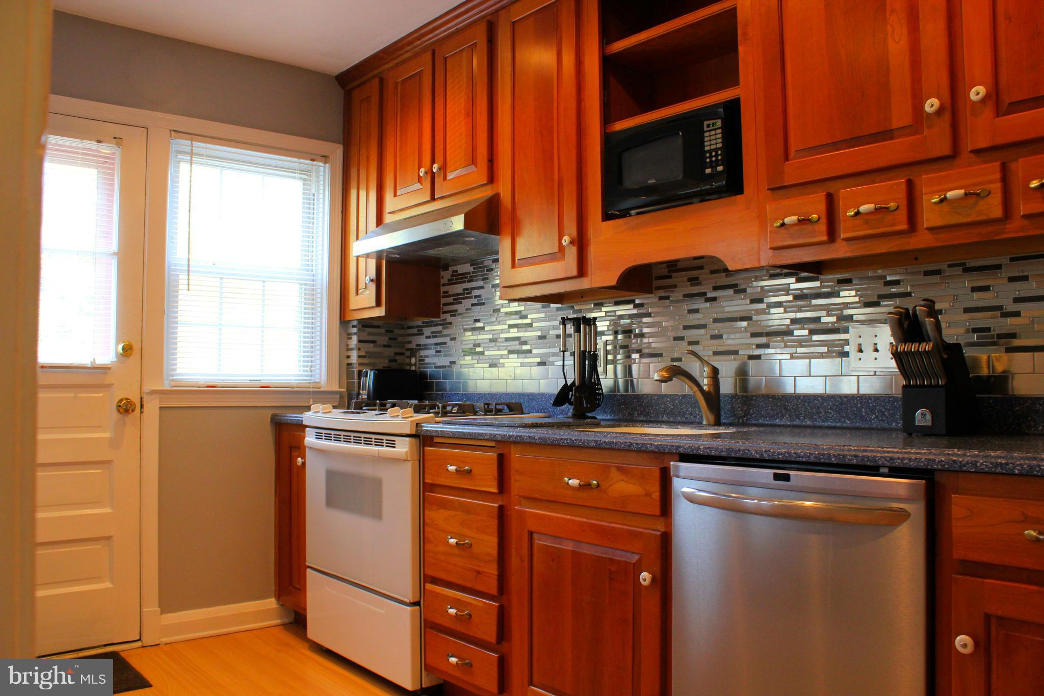 338 Dumbarton Road Baltimore, MD 21212 - Photo 10 of 30 a kitchen with stainless steel appliances granite countertop a stove and a microwave