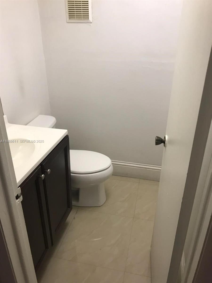 9375 Fontainebleau Boulevard, Unit L219 Miami, FL 33172 - Photo 12 of 13 a bathroom with a granite countertop sink and a toilet