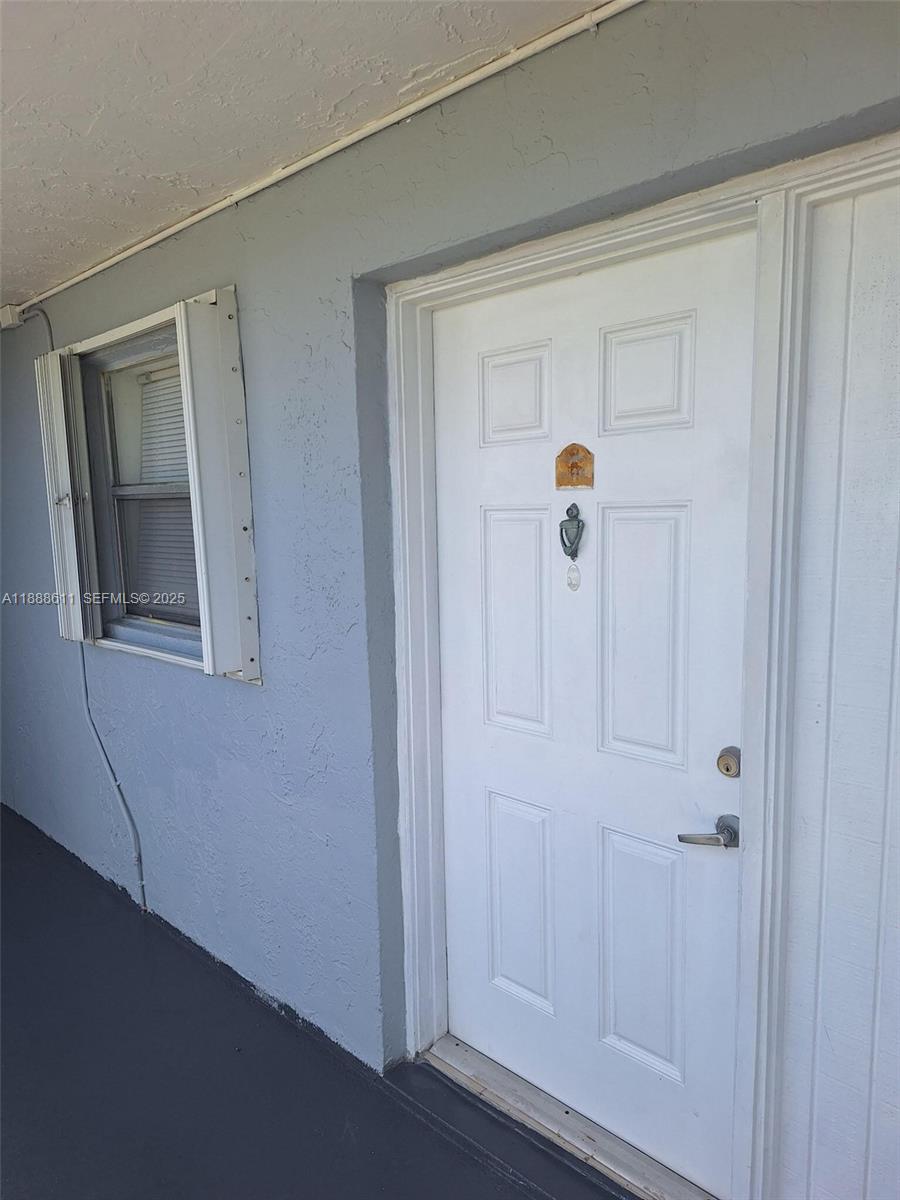 9375 Fontainebleau Boulevard, Unit L219 Miami, FL 33172 - Photo 3 of 13 a hallway with sliding door and windows