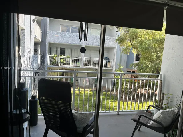 a dining room with furniture and a floor to ceiling window