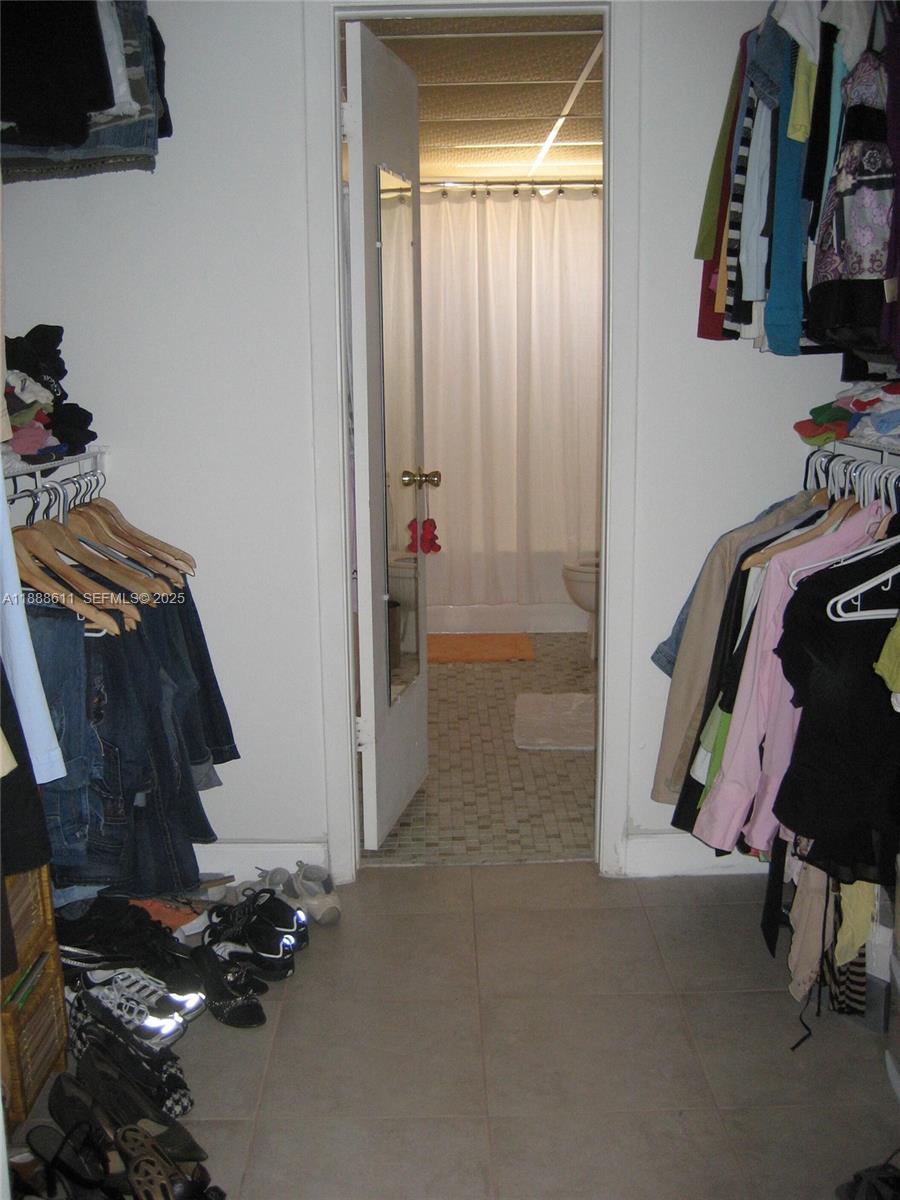 9375 Fontainebleau Boulevard, Unit L219 Miami, FL 33172 - Photo 10 of 13 a view of walk in closet with clothes and shoes