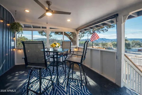 a view of a dining room with furniture one side kitchen view and wooden floor