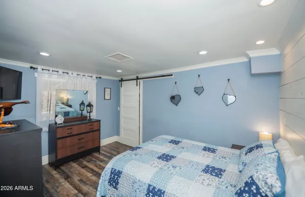 a bedroom with a bed and a mirror on dresser