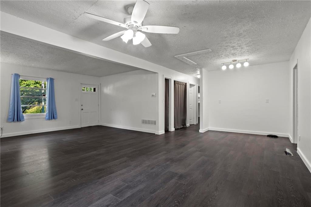 317 Argus Circle Northwest Atlanta, GA 30331 - Photo 9 of 21 an empty room with wooden floor chandelier fan and windows