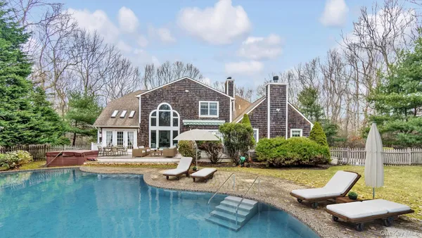 a front view of a house with swimming pool and furniture