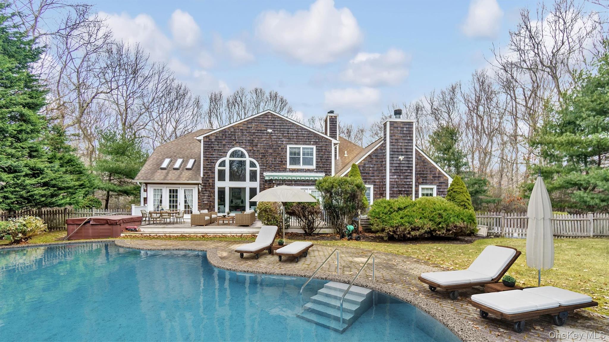 a front view of a house with swimming pool and furniture