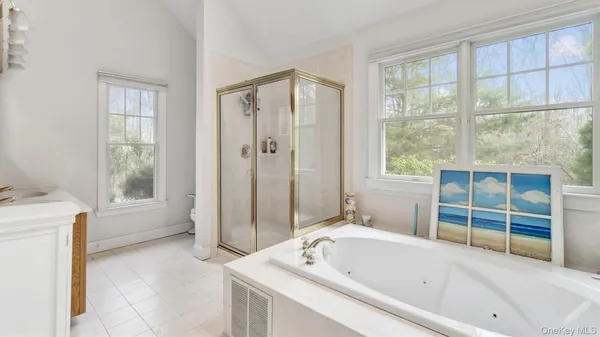 a bathroom with a tub a sink and a window