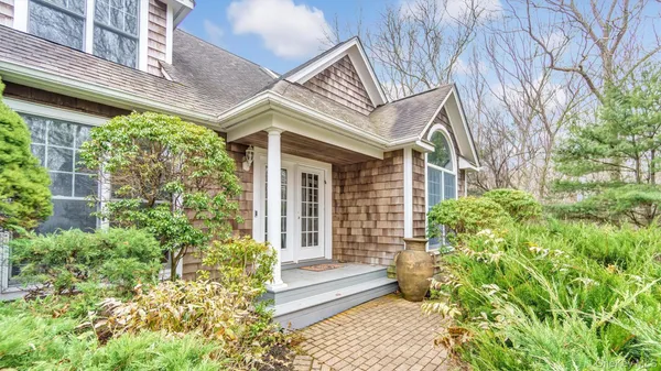 a view of a house with potted plants and a table and chair
