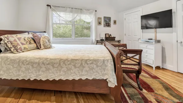 a bedroom with a bed and a flat screen tv