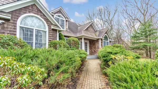 a view of a brick house with a large windows and flower plants