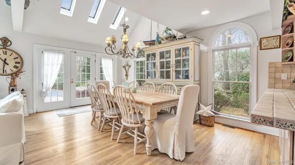 a view of a dining room with furniture a chandelier and wooden floor