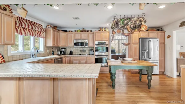 a kitchen with kitchen island granite countertop a stove and a wooden floors