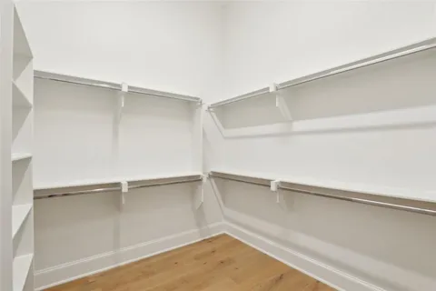 a large white bed sitting in a room next to a window
