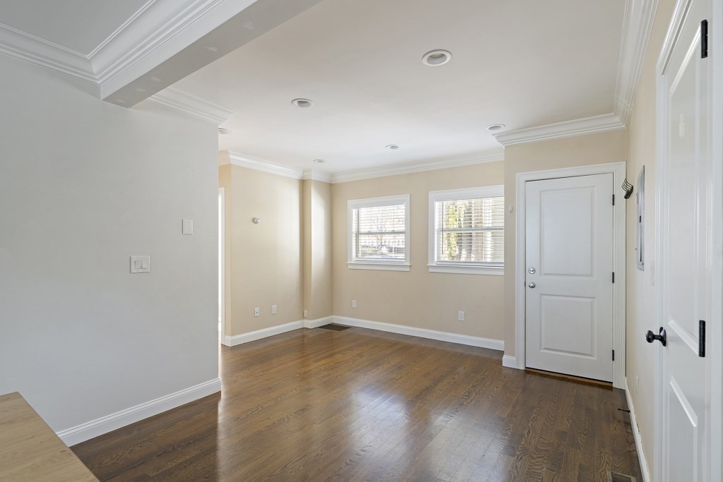 47 Notre Dame Street, Unit 1 Boston, MA 02119 - Photo 5 of 11 an empty room with wooden floor and windows
