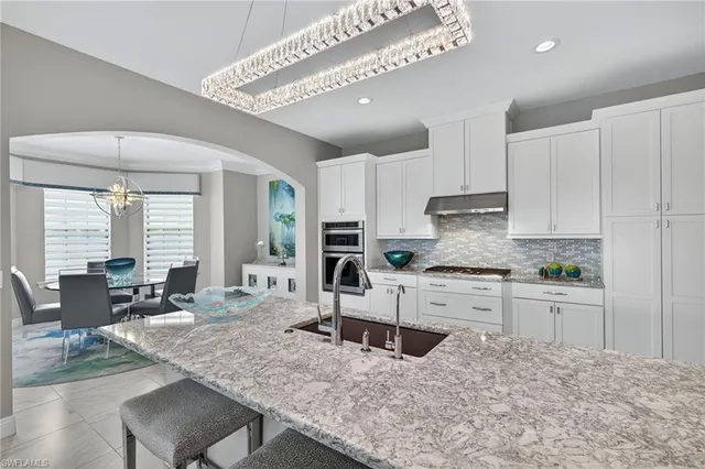a dining room with furniture a chandelier and wooden floor
