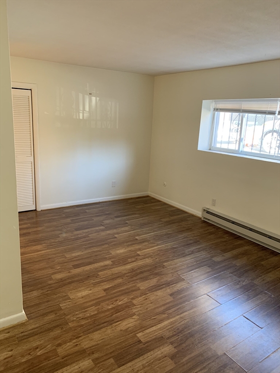 10 Scottfield Road, Unit B3 Boston, MA 02134 - Photo 4 of 15 wooden floor in an empty room with a window