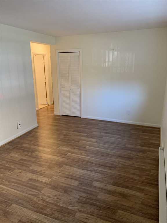 10 Scottfield Road, Unit B3 Boston, MA 02134 - Photo 6 of 15 a view of an empty room with wooden floor and a window