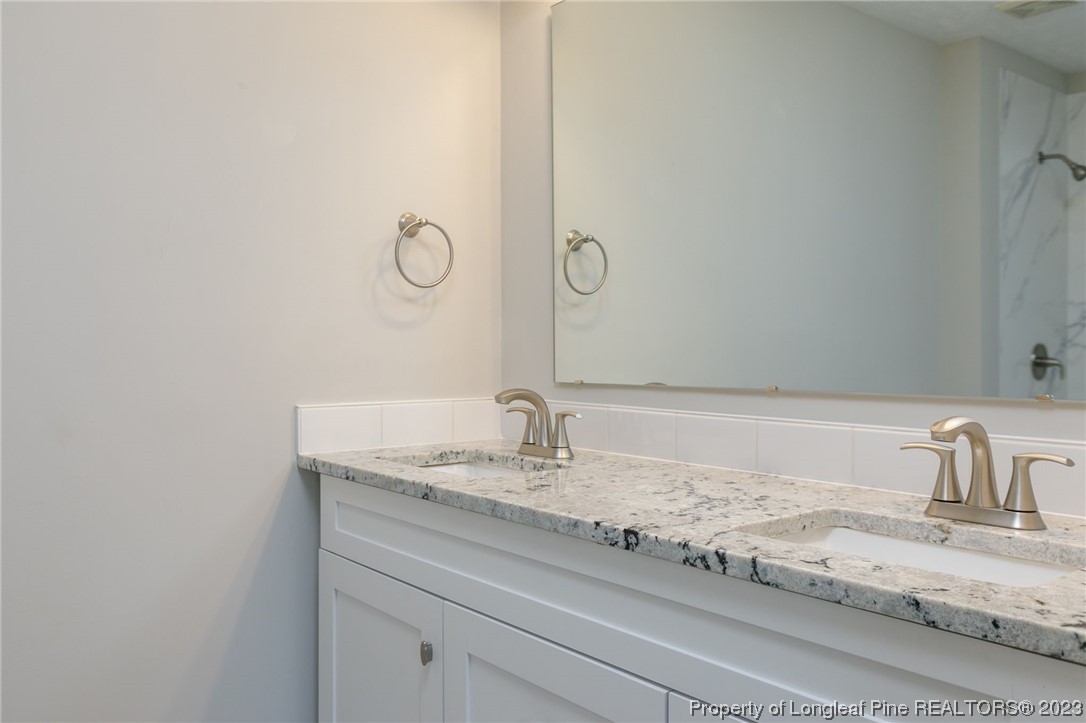 942 Rim Road Fayetteville, NC 28314 - Photo 7 of 14 a bathroom with a granite countertop sink and a mirror