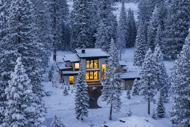 a front view of a house with large trees