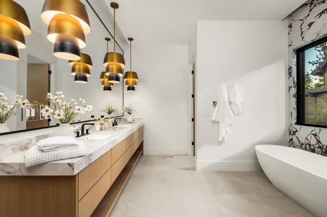 a bathroom with a double vanity sink mirror and bathtub