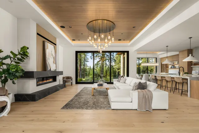 a living room with fireplace furniture and a large window