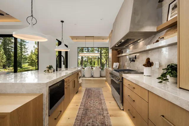 a large kitchen with kitchen island a large counter space a sink stainless steel appliances and cabinets