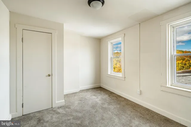an empty room with windows and closet
