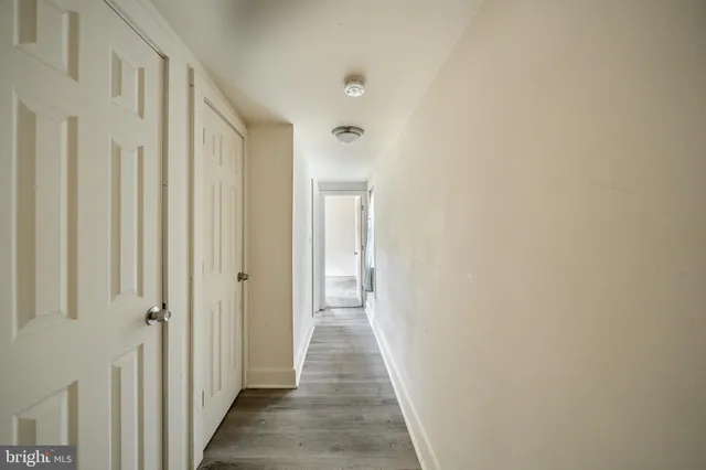 a view of a hallway with wooden floor